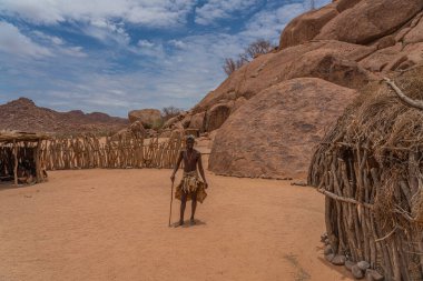 DAMARALAND, NAMIBIA - 13 Ocak 2020 Damara erkekleri Damaraland, Namibya 'daki Damara Canlı Müzesi' nde geleneksel giysiler içinde