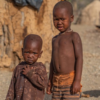 KORIXAS. NAMIBIA, 13 OCAK. 2020: Himba kabilesi çocukları kalır ve Korixas, Namibya yakınlarındaki Himba köyündeki bir kabile kulübesine bakar.