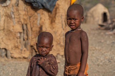 KORIXAS. NAMIBIA, 13 OCAK. 2020: Himba kabilesi çocukları kalır ve Korixas, Namibya yakınlarındaki Himba köyündeki bir kabile kulübesine bakar.