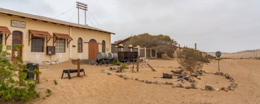 KOLMANSKOP. NAMIBIA - 8 Ocak 2021: Namibya 'daki Alman Kolmanskop' taki Namib Çölü 'ndeki terk edilmiş binalarla Kolmannskuppe Hayalet Kasabası' ndaki elmas deposu
