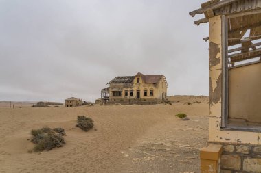 KOLMANSKOP. NAMIBIA - 8 Ocak 2021: Alman Kolmanskop 'taki Buchhalter evi - Namibya' daki terk edilmiş binalarla birlikte Kolmannskuppe Hayalet Kasabası