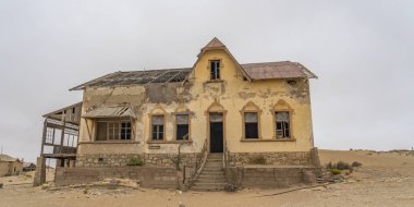 KOLMANSKOP. NAMIBIA - 8 Ocak 2021: Alman Kolmanskop 'taki Buchhalter evi - Namibya' daki terk edilmiş binalarla birlikte Kolmannskuppe Hayalet Kasabası