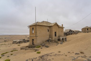 KOLMANSKOP. NAMIBIA - HAZİRAN 8.2021: Alman Kolmanskop - Namibya 'daki terk edilmiş binalarla birlikte Kolmannskuppe Hayalet Kasabası