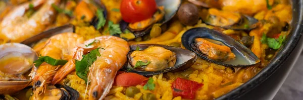 Spanish seafood Paella de Marisco, Paella Marinera with mussels, shellfish and scampis, panorama view