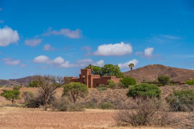 NAMIB DESERT, NAMIBIA - 9 Ocak 2021: Namib Naukluft Ulusal Parkı 'ndaki Duwisib Kalesi Mavi gökyüzü ve bulutları, Namibya, Afrika