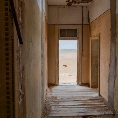 Namibya 'daki Kolmanskop-Kolmannskuppe Hayalet Kasabası' nda Namib Çölü 'ndeki terk edilmiş binaların bulunduğu bir koridora bakın.