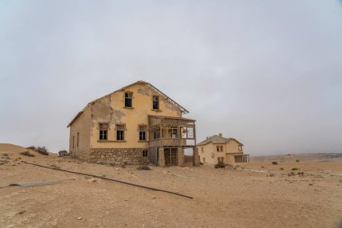 KOLMANSKOP, NAMIBIA - 8-2021: Alman Kolmanskop - Namibya 'daki terk edilmiş binalarla birlikte Kolmannskuppe Hayalet Kasabası
