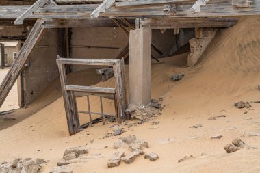 Alman Kolmanskop 'unda kumla dolu bir ev - Namibya' da terk edilmiş binalarla Kolmannskuppe Hayalet Kasabası