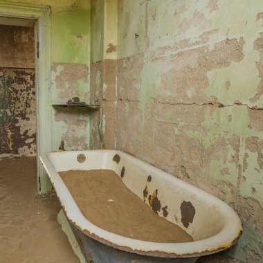 Alman Kolmanskop 'unda kum dolu bir küvet Namibya' daki terk edilmiş binaları olan Kolmannskuppe Hayalet Kasabası.