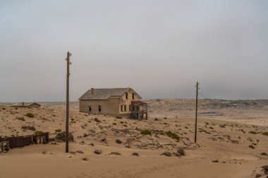 KOLMANSKOP, NAMIBIA - 8-2021: Alman Kolmanskop - Namibya 'daki terk edilmiş binalarla birlikte Kolmannskuppe Hayalet Kasabası