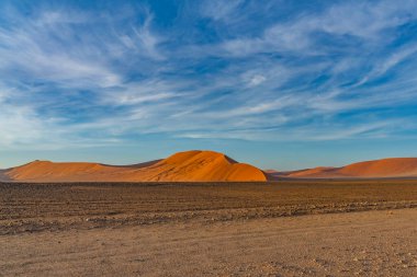 Sossusvlei 'deki Namib Çölü' nün kumulları, arka plan mavi gökyüzü güzel bulutlarla, Namib Naukluft Rand, Namibya.