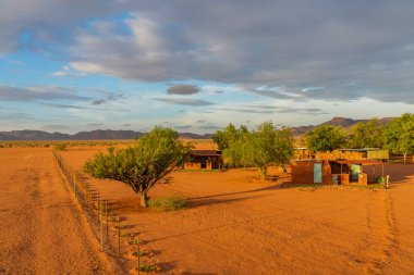 BETTA, NAMIBIA - HAZİRAN 05.2021: Namib Naukluft Milli Parkı, Namibya 'da gün batımında Kalahari Çölü' ndeki binalarla Betta Kampı
