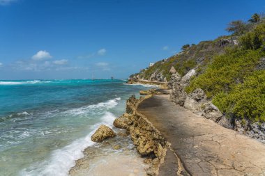 Mujeres Adası Güney Noktası Punta Sur Cancun Meksika Adası turkuvaz suyu ve kayalık kıyı şeridi, arka plan mavi gökyüzü
