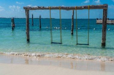 Swing over turquoise water at Isla Mujeres, Cancun, Mexico clipart