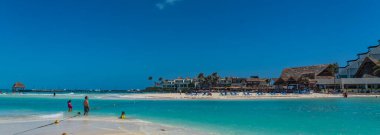 ISLA MUJERES, MEXICO - 12 Mart. 2021: Playa Norte - kristal berrak turkuaz su, beyaz kum ve insanlar ile kuzey sahili, Isla Mujeres. panorama