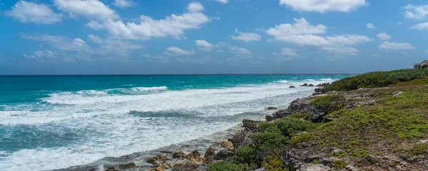 Güney Punta Sur Cancun Mexico Adası 'ndaki Mujeres Adası' nda turkuaz suyla Rocky kıyı şeridi, güzel bulutlu mavi gökyüzü.