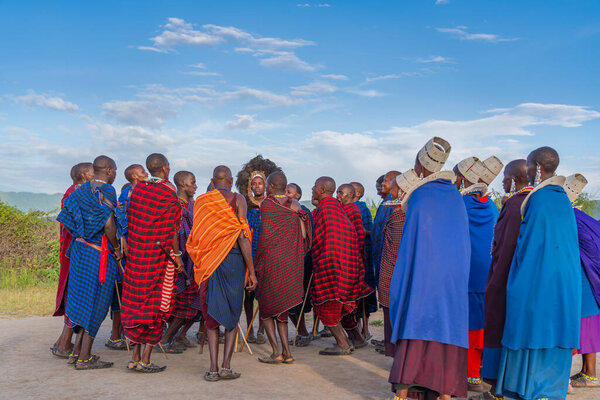 NGORONGORO, TANZANIA - February 15, 2020: Group of massai warrior stay in the round and participating a traditional dance, selected focus