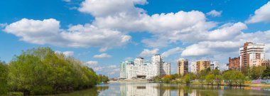 KRASNODAR, RUSSIA - APRIL 24.2021: Krasnodar şehri ve Kuban Nehri ufuk çizgisi panoramik görünümü. İlkbaharda güzel bulutlu gökyüzü. Panorama