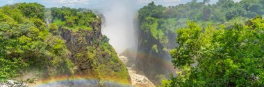 Zambezi Nehri üzerinde Victoria Şelalesi üzerinde gökkuşağı, Zambiya sınırı ve mavi gökyüzü ile Zimbabwe panorama manzarası