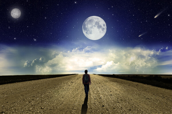 Man walking on the road at night in the moonlight