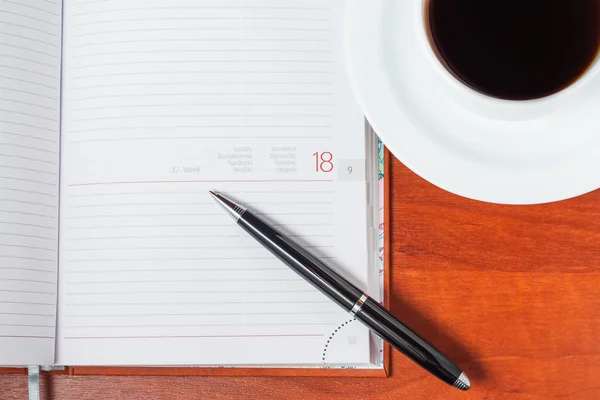 Tagebuch auf dem Tisch und eine Tasse Kaffee — Stockfoto