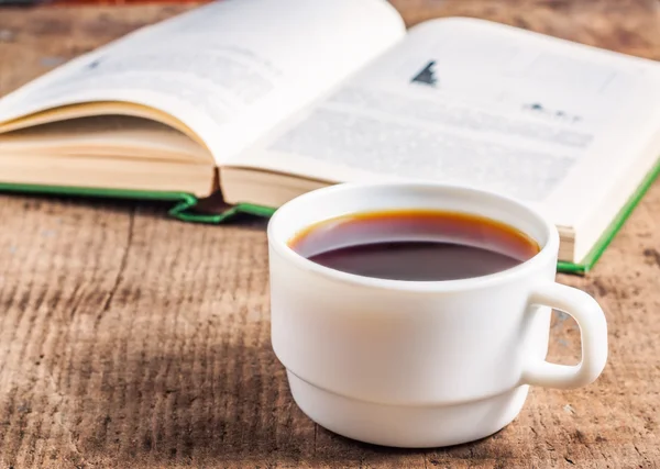 Öppen bok och en kopp kaffe på bordet — Stockfoto