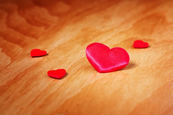 Corazones rojos sobre una superficie de madera — Foto de Stock