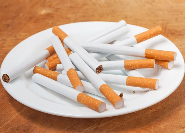 Muchos cigarrillos en el plato —  Fotos de Stock