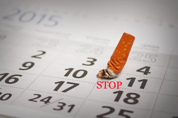 Spento mozzicone di sigaretta sul calendario — Foto Stock