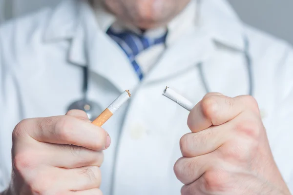 Лікар розбиває сигарету — стокове фото