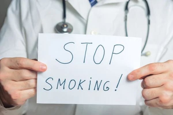 Doutor detém uma área de transferência com parar de fumar rótulo Imagens Royalty-Free