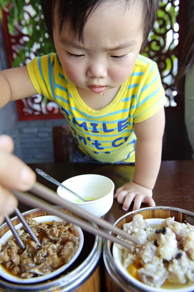 Um bebê bonito está comendo — Fotografia de Stock