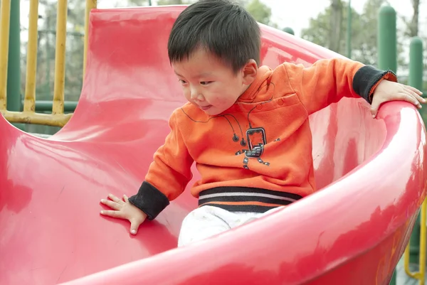 Baby playing on sliding board — Stock Photo, Image