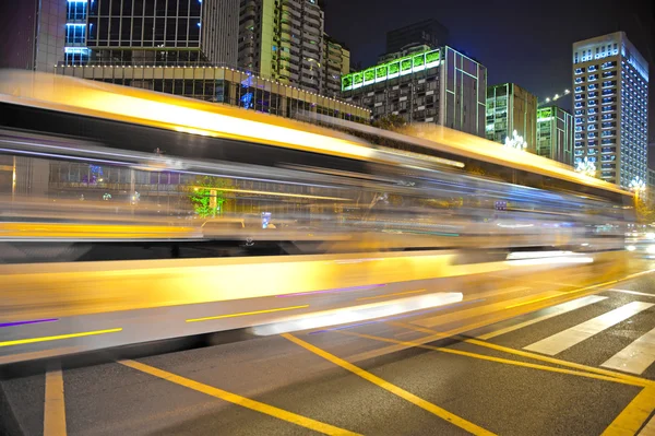 Trilhas leves de ônibus de alta velocidade e embaçadas no centro da cidade — Fotografia de Stock