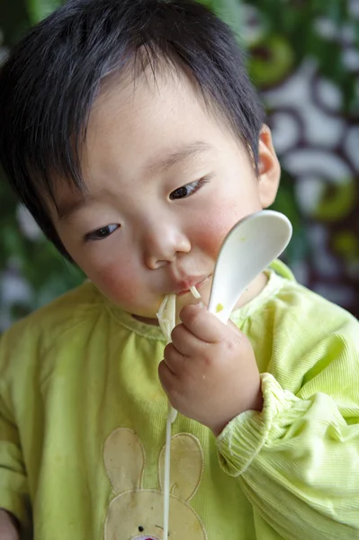 Un bambino carino sta mangiando al ristorante — Foto Stock