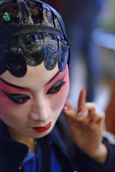 Uma atriz de ópera chinesa está pintando seu rosto antes da performa — Fotografia de Stock