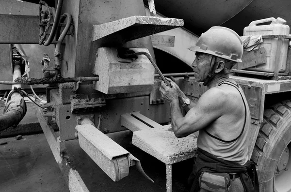 Hardworking laborer and truck-concrete mixer on construction site — Stock Photo, Image