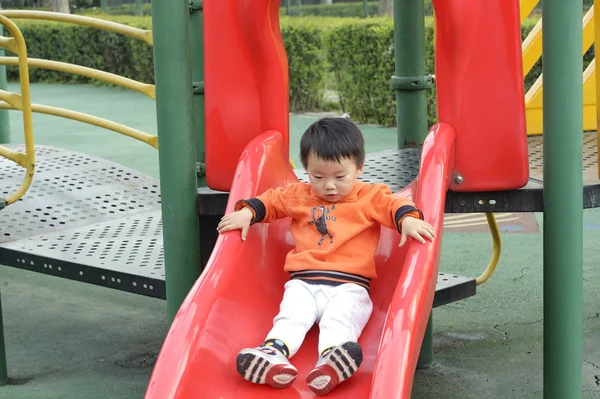 Baby playing on sliding board — Stock Photo, Image