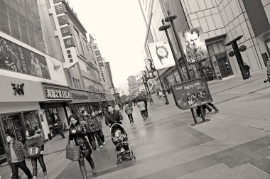 İnsanlar yoğun bir yaya alışveriş caddesi geçer