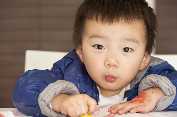 Um bebê bonito está pintando na mesa — Fotografia de Stock