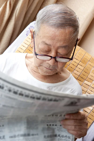 Un hombre mayor está leyendo el periódico. —  Fotos de Stock