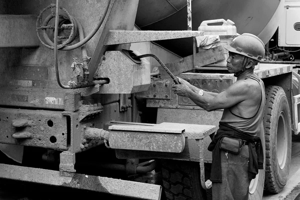 Hardworking laborer and truck-concrete mixer on construction site — Stock Photo, Image