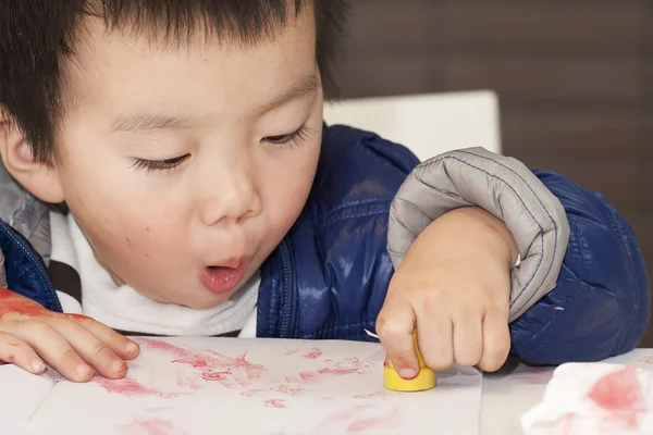 Um bebê bonito está pintando na mesa — Fotografia de Stock