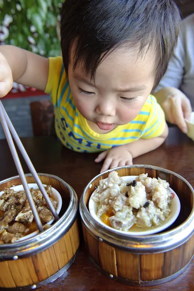 Um bebê bonito está comendo — Fotografia de Stock