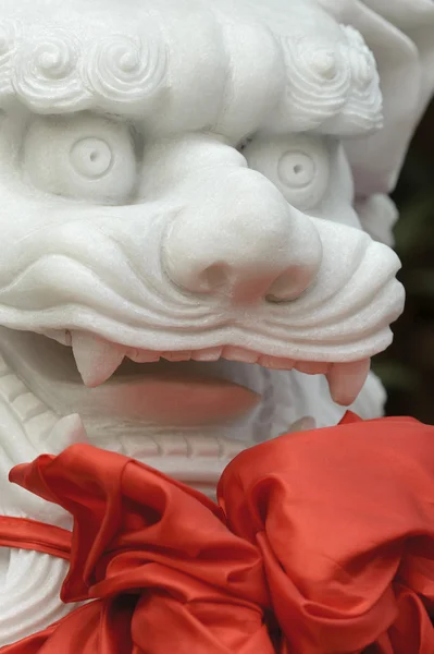 Leão escultura tradicional chinesa com seda vermelha — Fotografia de Stock