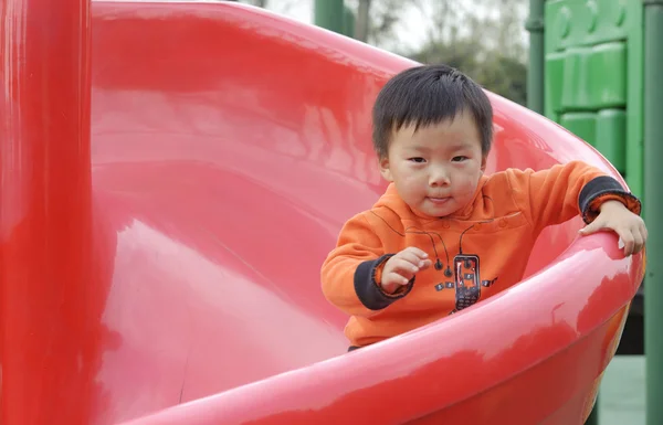 Baby playing on sliding board — Stock Photo, Image