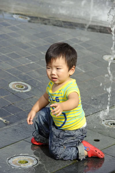 Roztomilé dítě hraje fontána — Stock fotografie