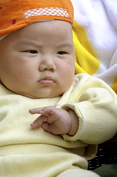 Un bambino carino con un cappuccio arancione — Foto Stock