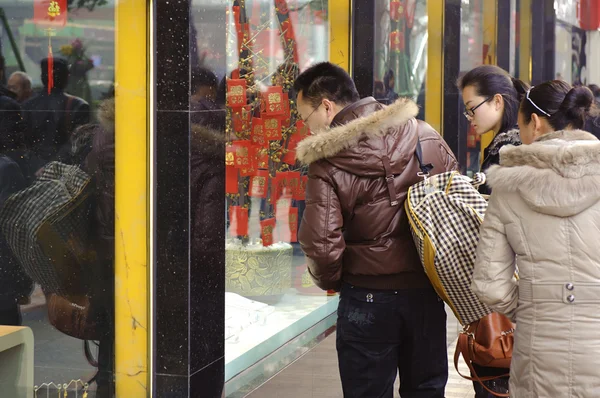 A man and women stop to look in the window of a gold shop — Stock Photo, Image