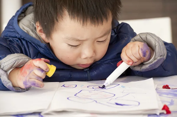 Een schattige baby is schilderen op tafel — Stockfoto